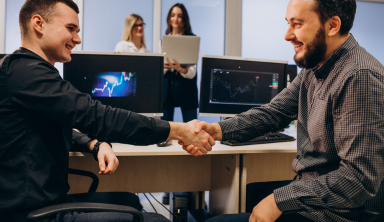 IT support consultation with professionals shaking hands in office.
